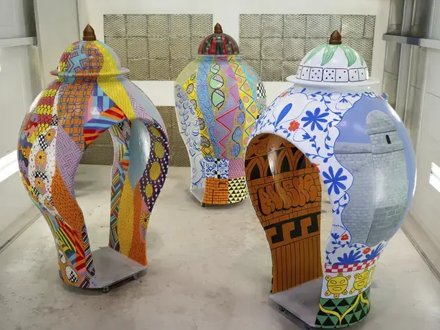Three large sculptures shaped like clay vessels that have adult-sized walk-ways cut through them. The sculptures are covered in colorful designs reminiscent of graffiti.